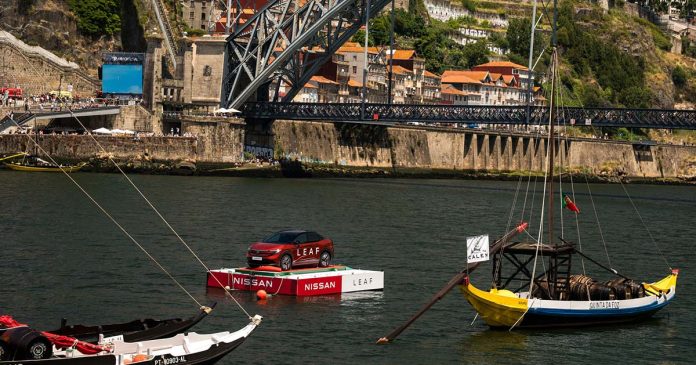 Nissan LEAF sobre uma plataforma flutuante no Rio Douro entre dois barcos rabelos durante o Air Invictus