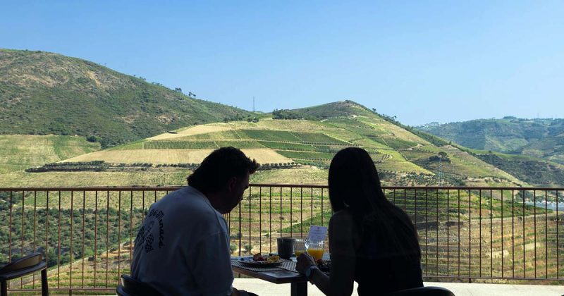 Escapadinha no Douro com casal a tomar o pequeno-almo&ccedil;o numa varanda com vista para as vinhas