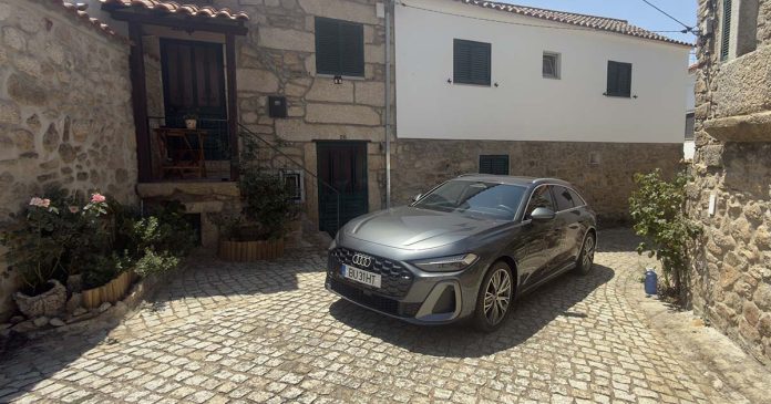 Audi A5 e-hybrid Avant quattro numa rua de calçada entre casas tradicionais