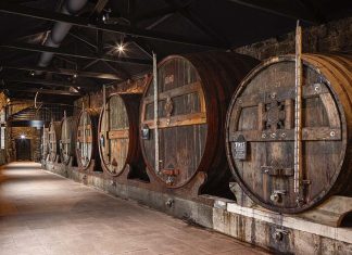 Caves de vinho do Porto: nova experiência museológica chega às Caves Burmester Interior das caves de vinho do Porto da Burmester, em Vila Nova de Gaia, com balseiros históricos de envelhecimento