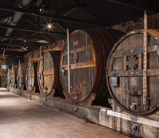 Caves de vinho do Porto: nova experiência museológica chega às Caves Burmester Interior das caves de vinho do Porto da Burmester, em Vila Nova de Gaia, com balseiros históricos de envelhecimento