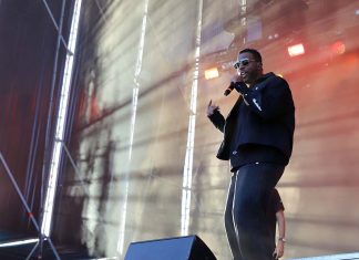 MEO Kalorama 2026 viveu a união lusófona de Criolo, Amaro e Dino num segundo dia marcado por fortes contrastes Dino d'Santiago em palco a cantar sob iluminação cénica e efeitos de luz no MEO Kalorama