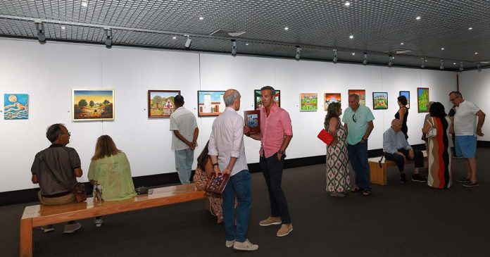 Visitantes observam as obras do Salão Internacional de Pintura Naïf na Galeria de Arte do Casino Estoril