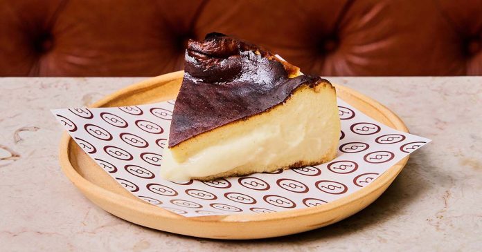 Tarte basca de Hugo Candeias Fatia de tarte basca de Hugo Candeias com interior cremoso e superfície caramelizada