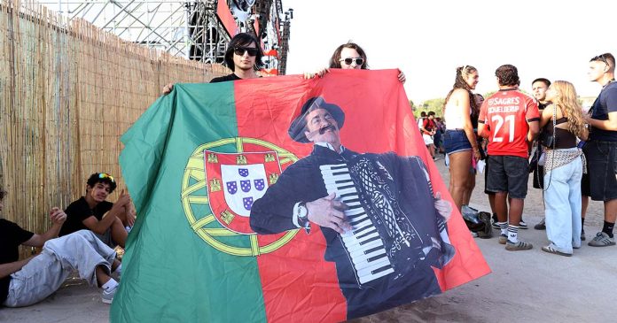 Bandeira portuguesa com imagem de Quim Barreiros no Sol da Caparica Último dia do Sol da Caparica com público a segurar bandeira portuguesa com imagem de Quim Barreiros