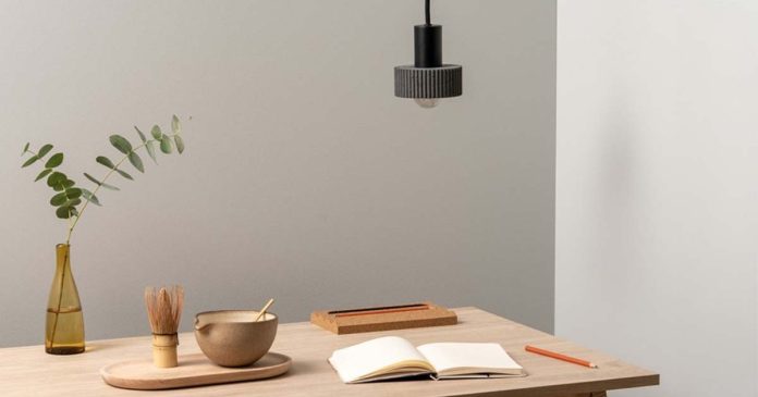 Design de iluminação com candeeiro suspenso sobre mesa de madeira
