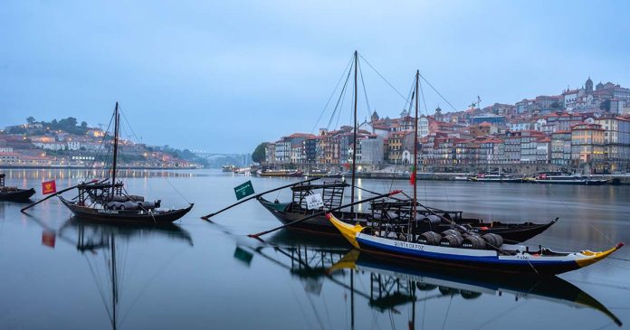 Barcos rabelos e pipas de Vinho do Porto no Douro Barcos rabelos no Douro com pipas de Vinho do Porto. Alusão ao Port Wine Day 2026