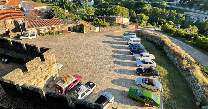 Automóveis clássicos estacionados junto a muralhas numa vista aérea durante o Ribacôa Clássicos